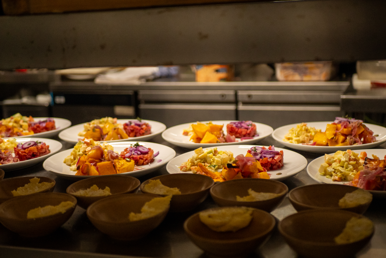 Plated dishes lined up on the pass at The Warren